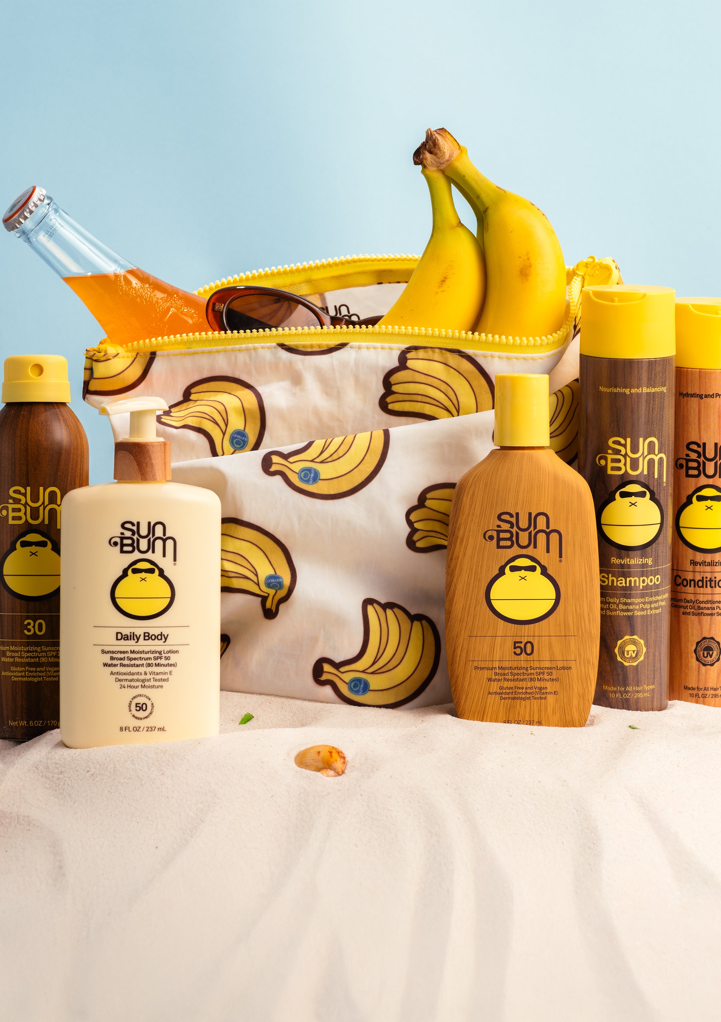 Sun Bum skincare and hair care products with a banana-themed pouch on a light blue background.