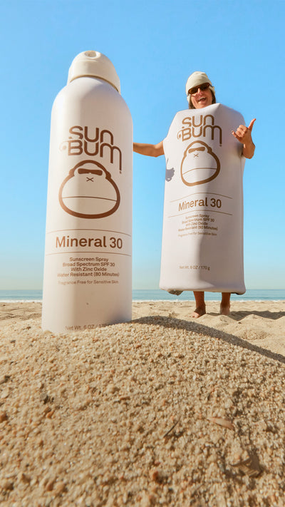 Person wrapped in a Sun Bum Mineral SPF 30 lotion bottle.