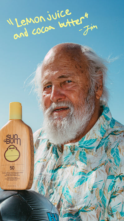 Man holding a Sun Bum sunscreen bottle with text on a blue background