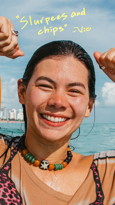 Person with wet hair smiling by the ocean, text 'Slurpees and chips' above