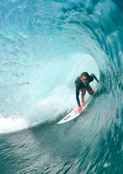 Woman surfing through a barrel 