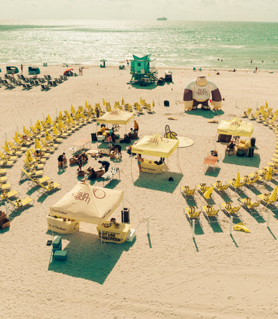 Yellow chairs in a circle on the beach with a giant Sun Bum Sonny inflatable 
